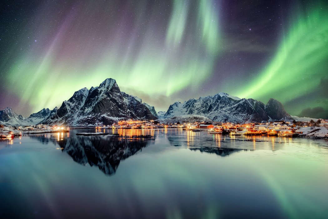 Nordlys set over en lille bygd ud til vandet