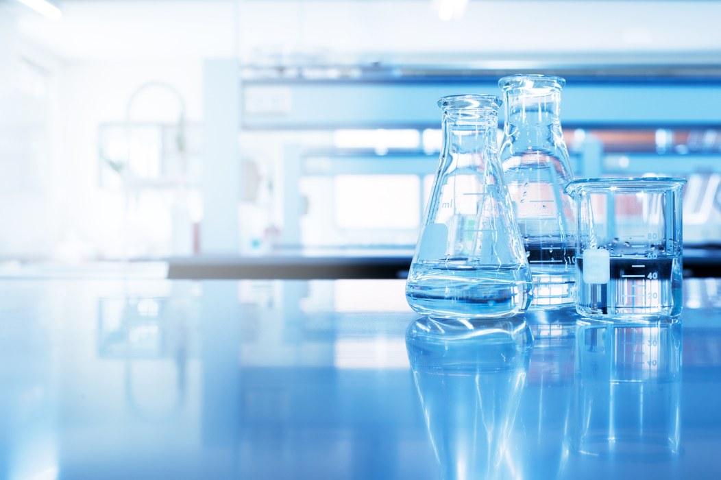 Nærbillede af tre reagensglas der står i et laboratorium